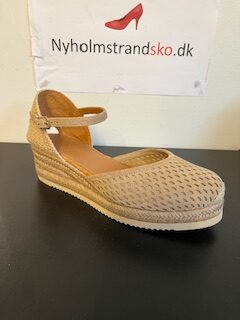 Unisa sandal på kilebund, lukket tå og hælkappe. Beige ruskind